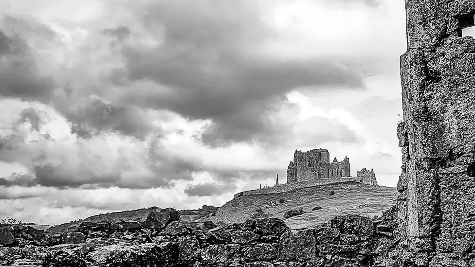 A black and white photo of a castle on a hill in Ireland