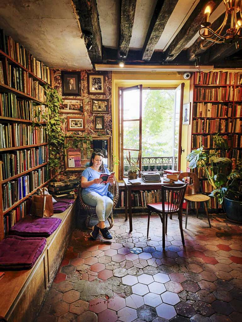 Woman reads a book in a bookstore in Paris